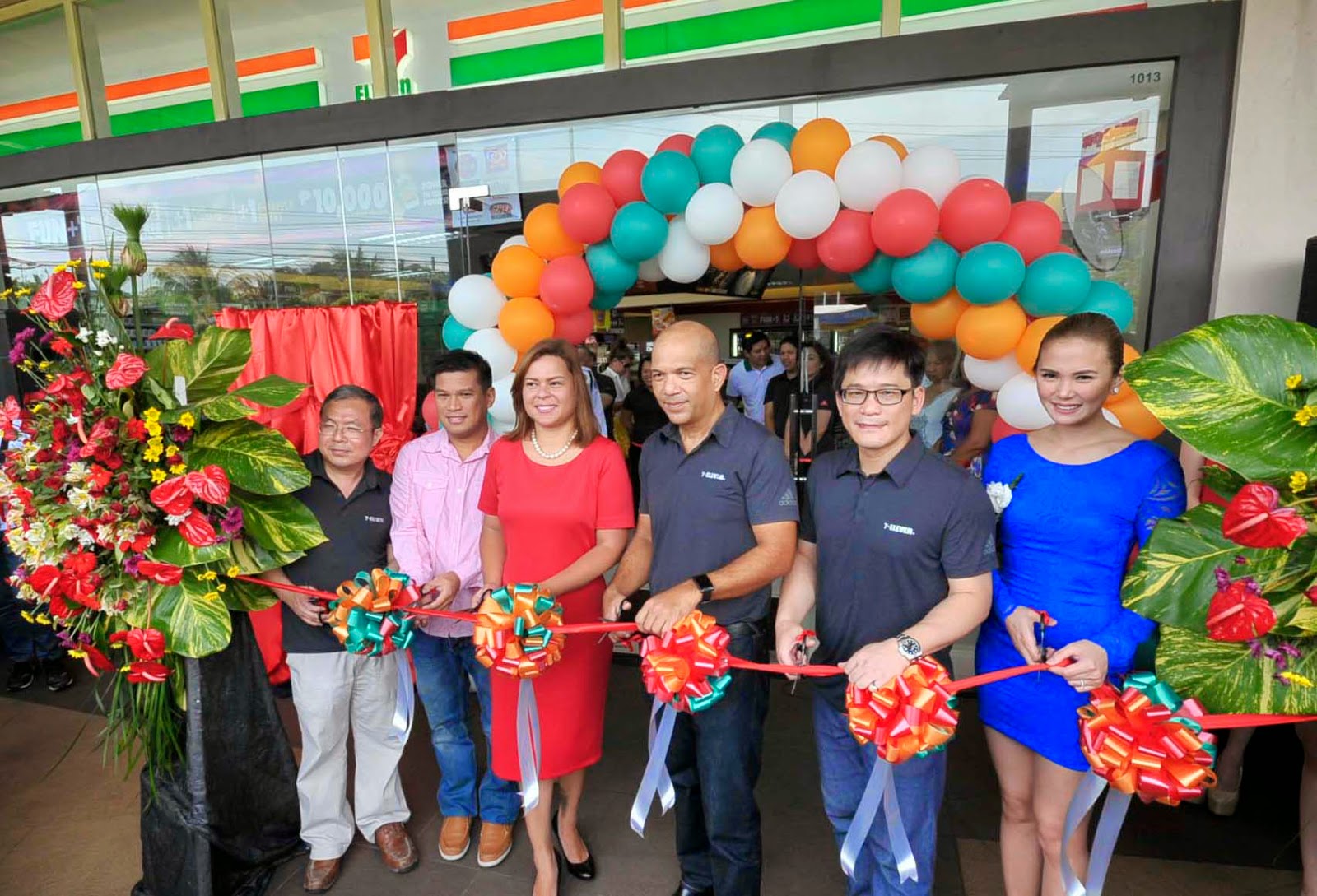  7-Eleven grand opening in Davao with people gathered and staff cutting ribbon
